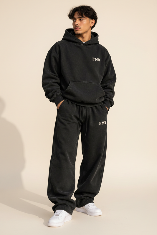 Model wearing [FMB] Forever My Brother Apparel black washed collegiate hoodie and matching sweatpants with white shoes