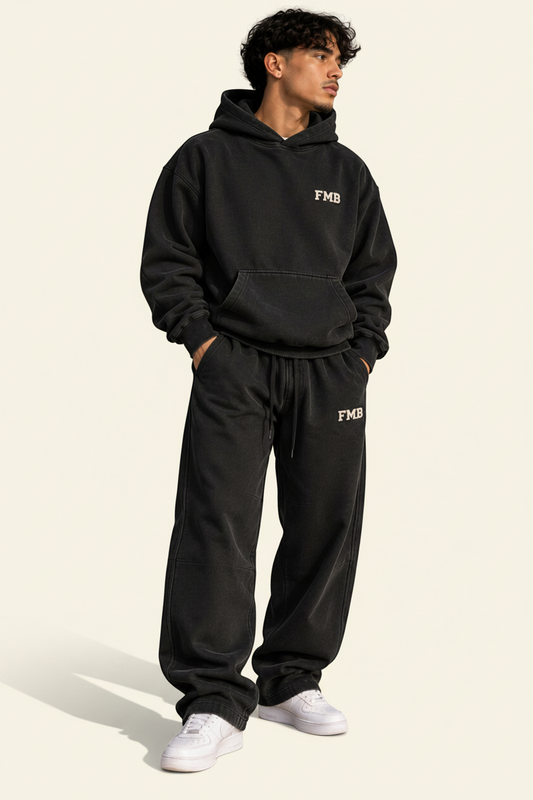 Model wearing FMB Forever My Brother Apparel black washed oversized hoodie and matching sweatpants with FMB logos.